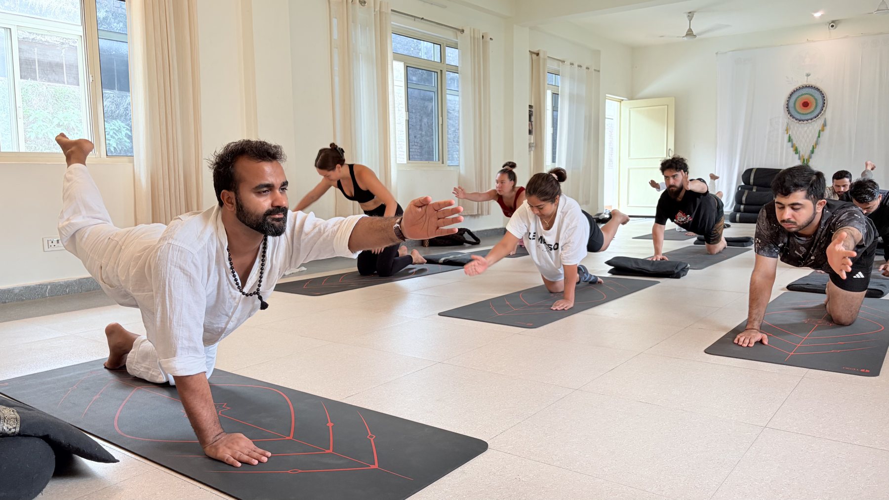 Shiva Shankra, founder of Witness Yoga, giving a hands-on adjustment during a yoga class in Tapovan, Rishikesh